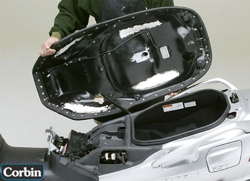 a person is holding Dual seat showing basepan with MPN printed and mounting brackets pre-installed