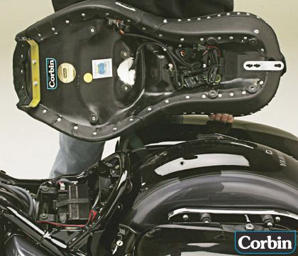 a person is holding Dual Touring seat showing rear side MPN printed, Heater wiring harness and mounting brackets pre-installed