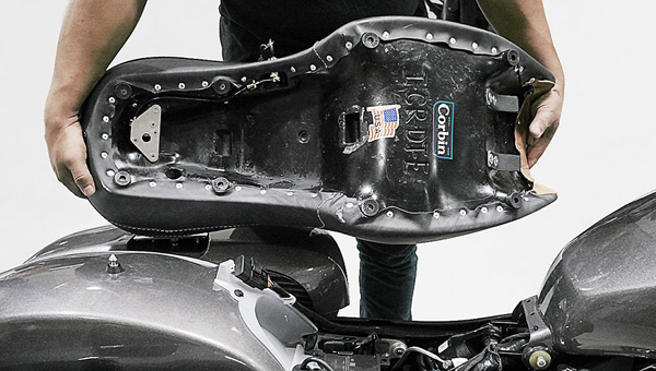 a person is holding Dual tour seat showing base pan with keylock system pre-installed