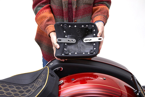 a person is holding rear seat showing rear side with mounting bracket pre-installed