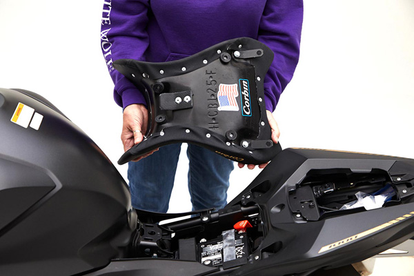 a person is showing the rear side of the front seat, with MPN printed and mounting brackets pre-installed