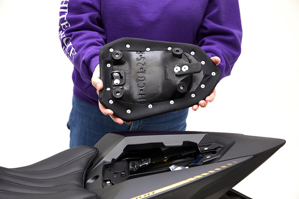a person is showing the rear side of the rear seat, with MPN printed and mounting brackets pre-installed