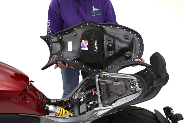  a person is holding the seat, showing rear side MPN printed and mounting brackets pre-installed