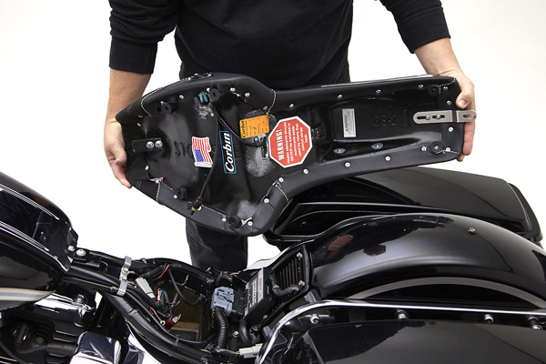 a person is holding the seat showing rear side MPN printed and mounting brackets pre-installed
