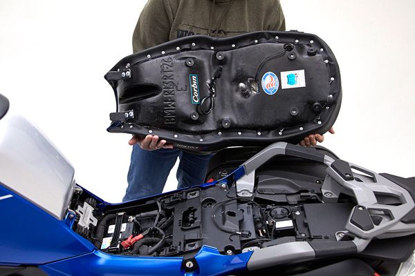 a person is holding seat showing rear side with mounting bracket pre-installed